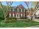 Charming two-story brick home with a well-manicured lawn and lush landscaping at 1216 Caribou Xing, Durham, NC 27713