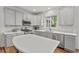 Bright kitchen features stainless appliances, light gray cabinets, stylish backsplash and quartz countertops at 1216 Caribou Xing, Durham, NC 27713
