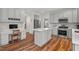 Modern kitchen with a center island, breakfast bar, and stainless steel appliances on hardwood floors at 1216 Caribou Xing, Durham, NC 27713