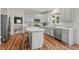 Bright kitchen features stainless appliances, light gray cabinets, stylish backsplash and hardwood floors at 1216 Caribou Xing, Durham, NC 27713