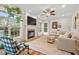 Sunlit living room with fireplace, neutral decor, large windows and wood floors offers comfortable living at 1216 Caribou Xing, Durham, NC 27713