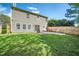 Back exterior showing large yard, complimented by mature trees and patio at 12433 N Exeter Way, Durham, NC 27703