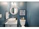 Stylish powder room with a vessel sink, round mirror, and elegant fixtures, creating a modern ambiance at 12433 N Exeter Way, Durham, NC 27703