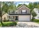 Charming two-story home featuring a 2-car garage, manicured lawn, and covered front porch at 12433 N Exeter Way, Durham, NC 27703