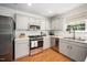 Modern kitchen with stainless steel appliances, light countertops, and wood floors at 12433 N Exeter Way, Durham, NC 27703