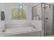 Bright bathroom featuring a soaking tub and a glass-enclosed shower with modern fixtures at 127 Sanderway Dr, Chapel Hill, NC 27516