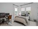 The spacious bedroom features a bed with a gray comforter, a desk, and large windows at 127 Sanderway Dr, Chapel Hill, NC 27516