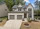 Beautiful two-story home featuring a white painted brick exterior, a two-car garage, and manicured landscaping at 127 Sanderway Dr, Chapel Hill, NC 27516