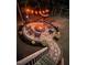 Inviting backyard fire pit area featuring stone patio, comfortable seating, hammock, and warm lighting for outdoor gatherings at 127 Sanderway Dr, Chapel Hill, NC 27516