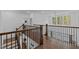 A hallway with hardwood floors, wrought iron railing, and views to the outside from the second story of the home at 127 Sanderway Dr, Chapel Hill, NC 27516