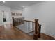 Upstairs hallway featuring hardwood floors and wrought iron railing, providing an airy and open feel at 127 Sanderway Dr, Chapel Hill, NC 27516