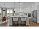 An open-concept kitchen with white cabinets, a center island with seating, and stainless steel appliances at 127 Sanderway Dr, Chapel Hill, NC 27516