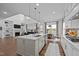A modern open-concept kitchen featuring a large island, stainless steel appliances, and stylish pendant lighting at 127 Sanderway Dr, Chapel Hill, NC 27516