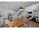 Open-concept living space features a modern kitchen, dining area, cozy fireplace, and a staircase to the upper level at 127 Sanderway Dr, Chapel Hill, NC 27516