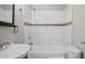 Bathroom featuring a white bathtub, tiled walls with decorative stripe, and a vanity with a sink at 1284 Railroad St, Henderson, NC 27536