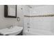 Bathroom featuring a white bathtub, tiled walls with decorative stripe, and a vanity with a sink at 1284 Railroad St, Henderson, NC 27536