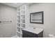 Bathroom vanity with dark cabinets, open shelving, and a framed mirror at 1284 Railroad St, Henderson, NC 27536