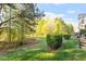 Green backyard with trees, bushes, and a small deck at 1307 Seattle Slew Ln, Cary, NC 27519