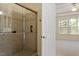 Glass enclosed walk-in shower with tile surround, and a large window into a bedroom at 1307 Seattle Slew Ln, Cary, NC 27519