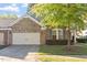 Charming brick home with a two-car garage and lush front lawn at 1307 Seattle Slew Ln, Cary, NC 27519