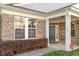 Charming home entrance with a stone facade, white columns, and a well-maintained landscape at 1307 Seattle Slew Ln, Cary, NC 27519