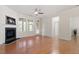 Bright living room features a fireplace, hardwood floors, a ceiling fan, and access to a sunroom at 1307 Seattle Slew Ln, Cary, NC 27519