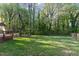 Exterior of home featuring a large yard, deck, and lush greenery at 1400 Rainwood Ln, Raleigh, NC 27615