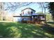 Rear exterior of home showing upper and lower wood deck overlooking a spacious green backyard with trees at 1400 Rainwood Ln, Raleigh, NC 27615