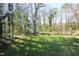 Beautiful backyard with a sprawling lawn, mature trees and a wood fence offers space for outdoor activities at 1400 Rainwood Ln, Raleigh, NC 27615