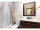 Bathroom featuring a sink with dark wood cabinet, mirror, toilet, and a bathtub with a shower curtain at 1400 Rainwood Ln, Raleigh, NC 27615