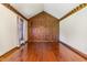 Spacious room with wood floors, a wooden accent wall, and natural light through the window at 1400 Rainwood Ln, Raleigh, NC 27615