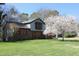 Lovely home with mature flowering tree, brick, siding, and well-kept lawn on a sunny day at 1400 Rainwood Ln, Raleigh, NC 27615