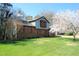 Lovely home with mature flowering tree, brick, siding, and well-kept lawn on a sunny day at 1400 Rainwood Ln, Raleigh, NC 27615