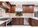 Well-lit kitchen with stainless steel appliances, wooden cabinets, and a view of the greenery outside at 1400 Rainwood Ln, Raleigh, NC 27615