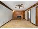 Living room boasting a cozy brick fireplace with wood mantle and flanking built-ins, carpet and ceiling fan with light at 1400 Rainwood Ln, Raleigh, NC 27615