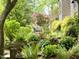 Lush backyard with mature plantings and a stone bench in a tranquil setting at 1425 Bascomb Dr, Raleigh, NC 27614