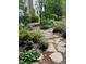 Landscaped backyard with a winding stone pathway and lush greenery at 1425 Bascomb Dr, Raleigh, NC 27614
