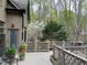 A backyard deck featuring a wooden railing and lattice, with potted plants and a view of the wooded green backyard at 1425 Bascomb Dr, Raleigh, NC 27614