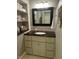 A powder room with granite counters, a framed mirror, vanity storage and an organized shelved linen closet at 1425 Bascomb Dr, Raleigh, NC 27614
