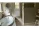 This is a bathroom featuring a soaking tub, a large glass enclosed shower, and travertine tiled floor at 1425 Bascomb Dr, Raleigh, NC 27614