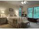 A light-filled bedroom with a decorative iron bed frame, bedside tables and windows overlooking lush greenery at 1425 Bascomb Dr, Raleigh, NC 27614