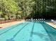 Sparkling community pool surrounded by lounge chairs and lush greenery, perfect for relaxation at 1425 Bascomb Dr, Raleigh, NC 27614
