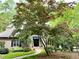 Charming home exterior with mature landscaping, brick walkway, and flowering trees at 1425 Bascomb Dr, Raleigh, NC 27614
