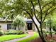 Charming home exterior with mature trees, landscaped yard, and inviting brick walkway at 1425 Bascomb Dr, Raleigh, NC 27614