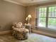 This is a peaceful sitting room with a floral-patterned chair and ottoman and a large window at 1425 Bascomb Dr, Raleigh, NC 27614