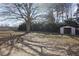 A spacious backyard with mature trees and a shed provides ample space for outdoor activities and storage at 1432 E Stonemason Dr, Fuquay Varina, NC 27526