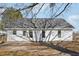 A well-maintained home exterior features a white siding and a gray roof that stands out against the natural surroundings at 1432 E Stonemason Dr, Fuquay Varina, NC 27526