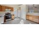 View of the kitchen with oak cabinets, stainless steel appliances, tile floors, and white refrigerator at 1432 E Stonemason Dr, Fuquay Varina, NC 27526