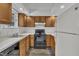Functional kitchen with white countertops, oak cabinets, black appliances, and laminate flooring at 1442 Barton Place Dr, Raleigh, NC 27608