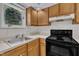 Angle of the kitchen with black stove, oak cabinets, and laminate countertops at 1442 Barton Place Dr, Raleigh, NC 27608